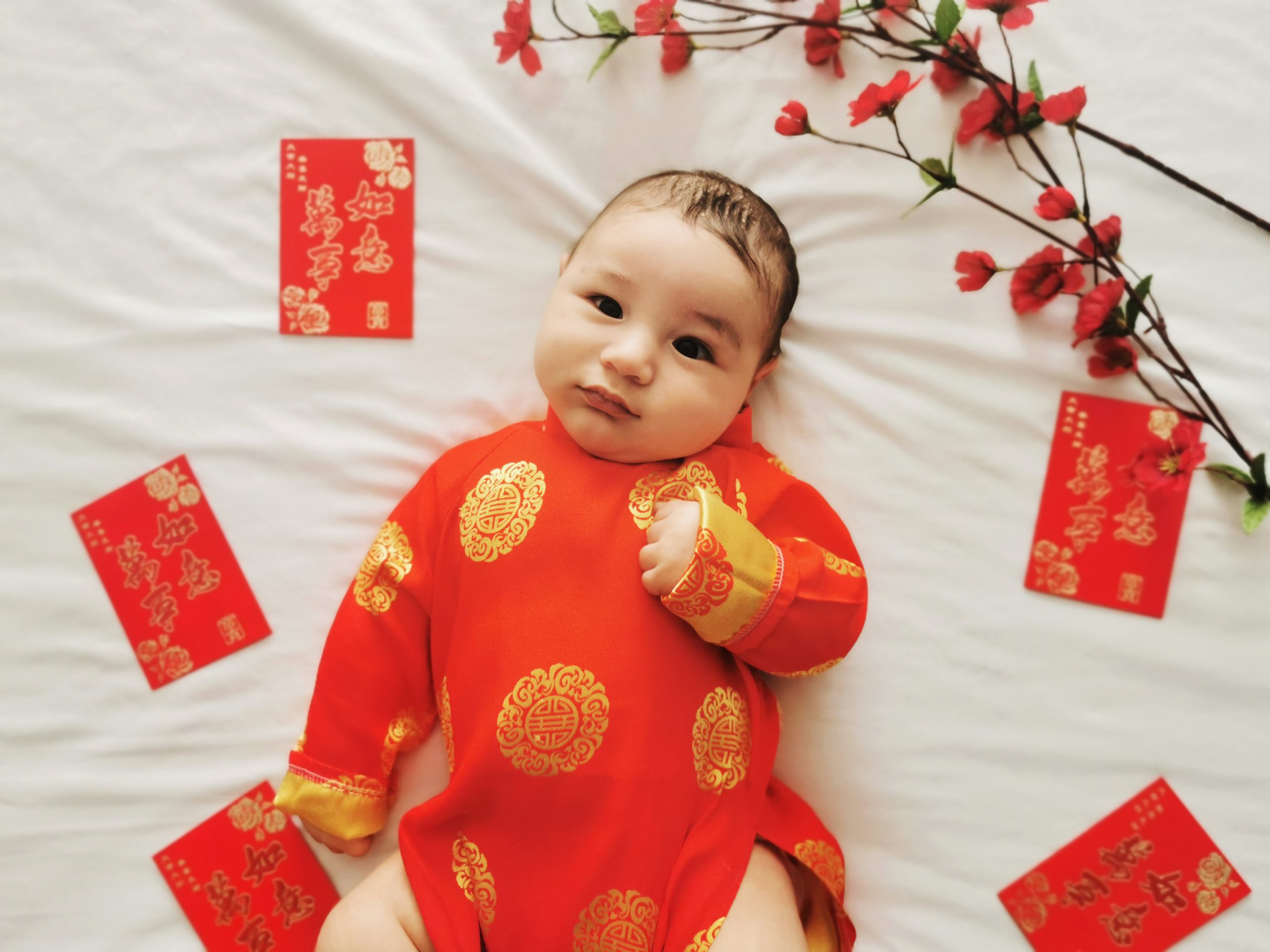 baby boy in Vietnamese ao dai for red egg and ginger celebration 100 days